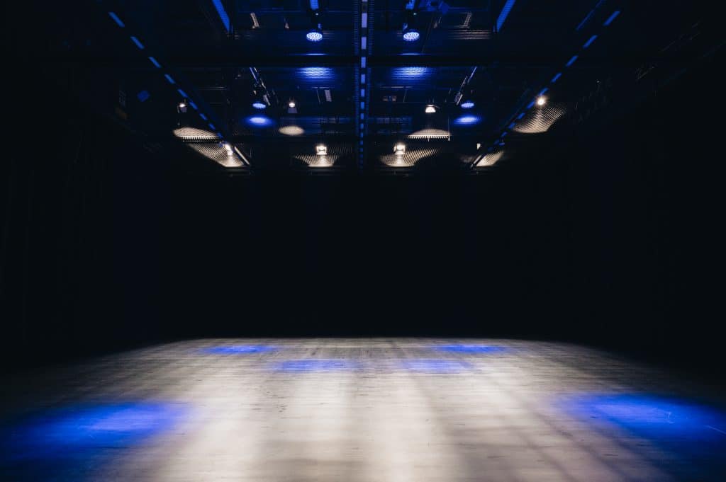 abgedunkelter Bühnenraum mit blauen Lichtern
